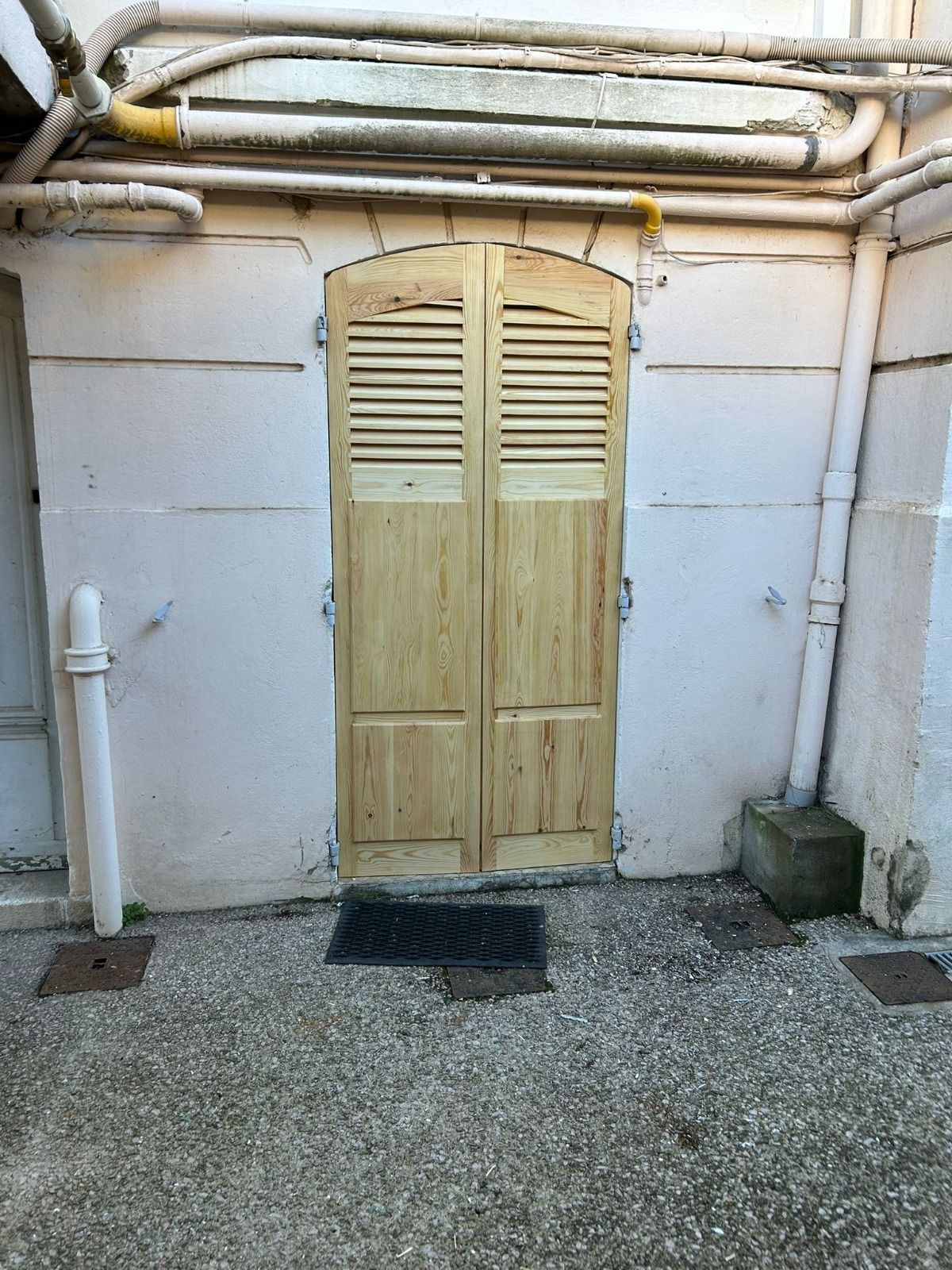 Persiennes bois patinées sur une porte extérieure